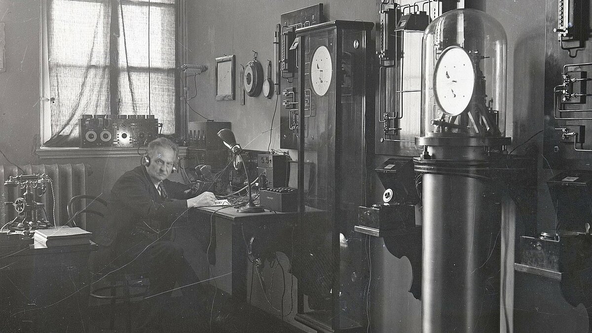 Pulksteņmeistars Ernsts Lips pie LU Astronomiskās observatorijas laika dienesta aparatūras ap 1923. gadu. LU Muzeja krājums Pulksteņmeistars Ernsts Lips pie LU Astronomiskās observatorijas laika dienesta aparatūras ap 1923. gadu. LU Muzeja krājums